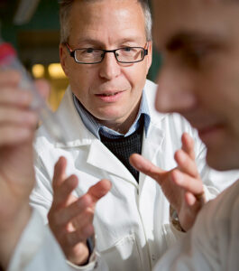 Dr. Jonas Bergquist in a lab, wearing a lab coat, explaining a concept.